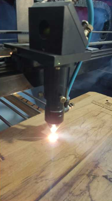 Máquina de laser CO₂ gravando uma tábua de madeira